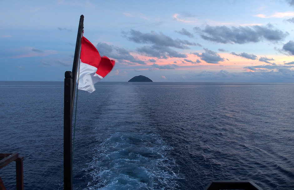 Leaving Manuk Island with Indonesian flag and sunset color